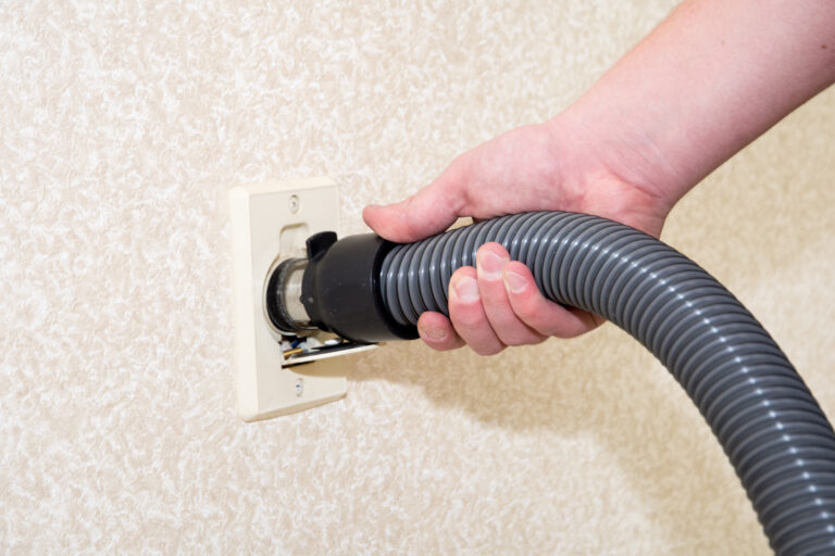Central vacuum cleaner hose connected to the wall